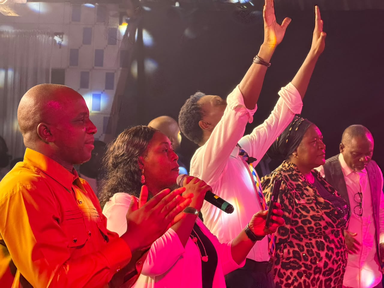 Leaders and members with hands lifted in praise together